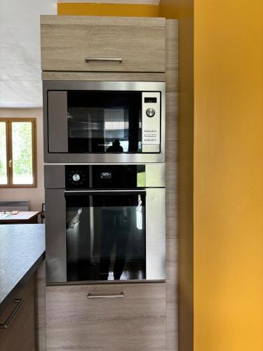 Il comprend une cuisine équipée d'un four micro-ondes et d'une armoire. dans l'établissement Le Morvan Cocon, à La Roche-en-Brenil