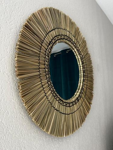 a rattan mirror hanging on a ceiling at L'Erable T2 climatisé in Trébas