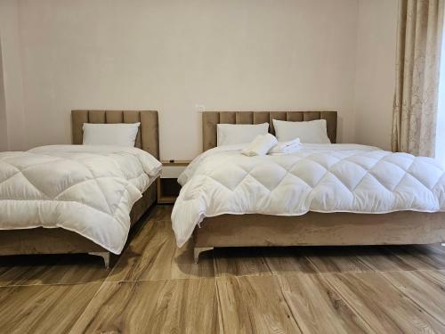 two beds sitting next to each other in a bedroom at Star Room's in Durrës
