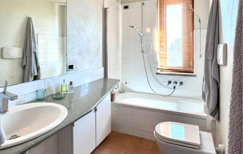 a bathroom with a sink and a tub and a toilet at Beautiful Home In Montalto Di Castro in Montalto di Castro