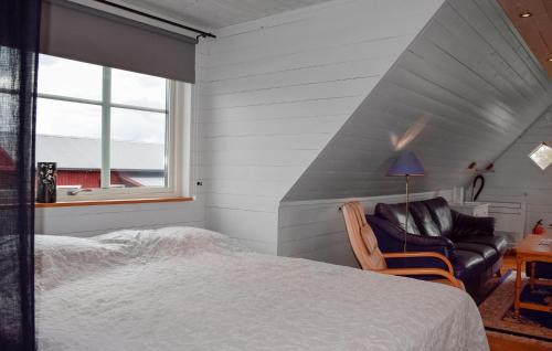 a bedroom with a bed and a couch and a window at Pet Friendly Apartment In Degeberga in Degeberga