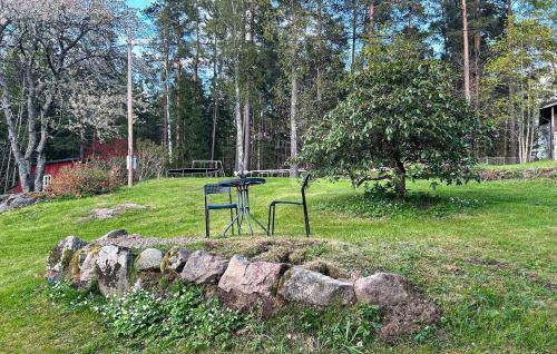 a stone wall with a table in a field at Pet Friendly Home In Söderköping in Söderköping