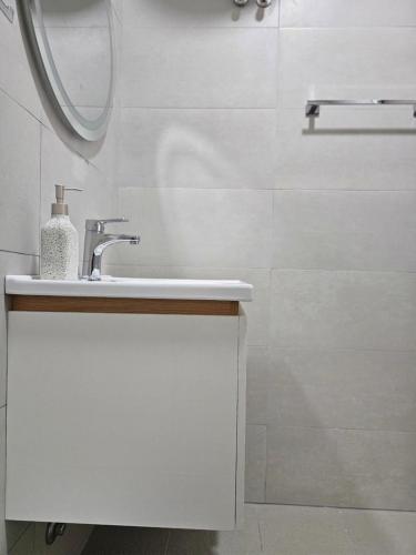 a white bathroom with a sink and a mirror at Star Room's in Durrës