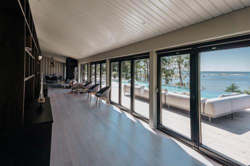 a room with a view of the ocean and a swimming pool at Hideout Villas - Villa Lövö in Espoo