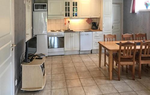 a kitchen with white appliances and a table and chairs at Nice Apartment In Sälen With Sauna in Sälen