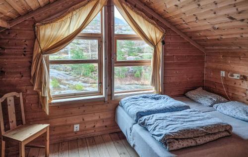 two beds in a room with a window at Lovely Home In Masfjordnes With Sauna in Sørkvingo