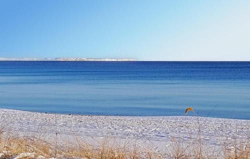 a beach with blue water and a flag on it at 2 Bedroom Awesome Apartment In Ystad in Ystad