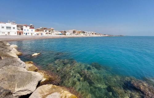 a beach with clear blue water and white buildings at 2 Bedroom Gorgeous Apartment In Moncofa in Moncófar