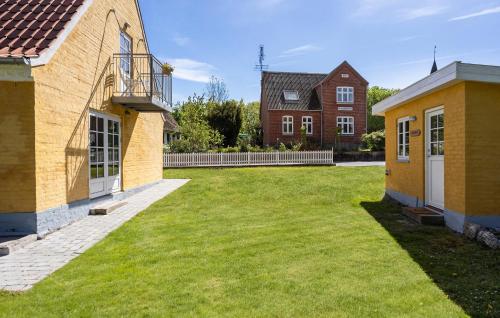 a yard between two buildings with a house at Awesome Home In Søby Ærø With Wifi in Søby