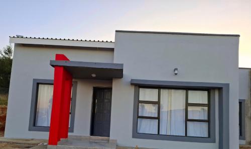 a rendering of a house with a red door at Melz & Sno Apartments in Mbabane