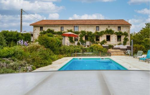 a villa with a swimming pool in front of a house at Charmante Maison Avec Piscine in Lizant