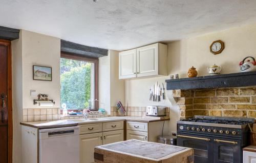 a kitchen with white appliances and a brick wall at Charmante Maison Avec Piscine in Lizant