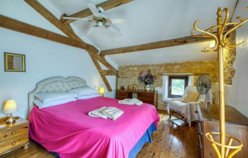 a bedroom with a pink bed and a ceiling at Charmante Maison Avec Piscine in Lizant