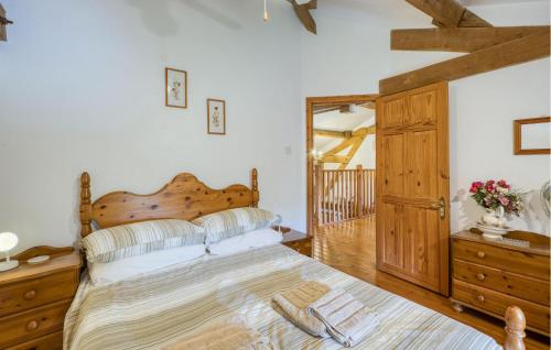 a bedroom with a large bed with a wooden headboard at Charmante Maison Avec Piscine in Lizant