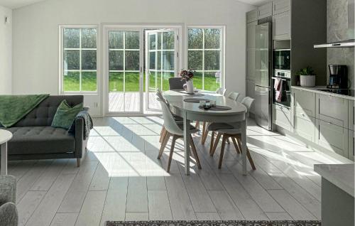 a kitchen and living room with a table and chairs at Gorgeous Home In Färjestaden in Färjestaden
