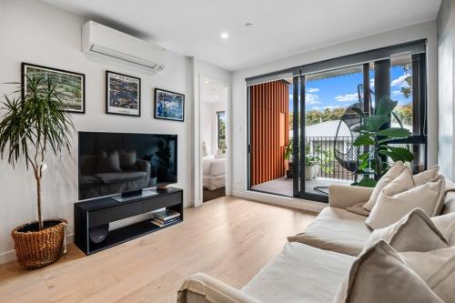 a living room with a couch and a fireplace at Tranquil 2 Bd Apt with AC, WIFI, & 10min from CBD in Auckland
