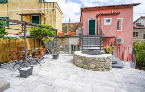 a patio with a fire pit and a house at Stunning Home In Costarainera in Costarainera