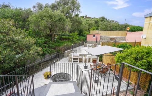 an outdoor patio with a fence and tables and chairs at Stunning Home In Costarainera in Costarainera