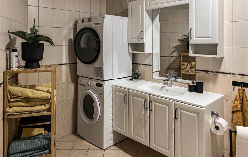 a kitchen with a washing machine and a sink at 3 Bedroom Beautiful Home In Sirevåg in Sirevåg