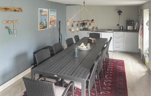 a dining room with a black table and chairs at Cozy Home In Thyborøn With Wifi in Thyborøn