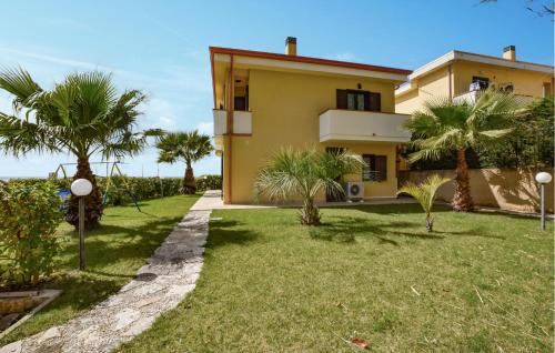 a house with palm trees in front of a yard at L'onda Dolce in Diamante