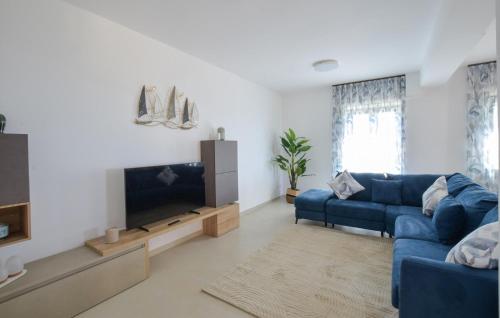 a living room with a blue couch and a tv at L'onda Dolce in Diamante