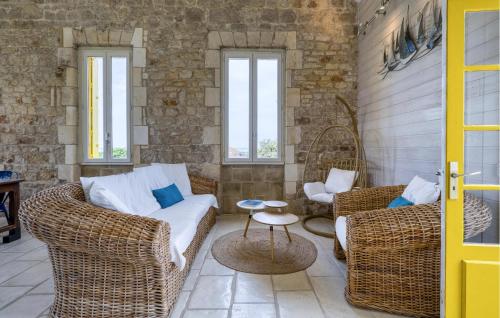 un salon avec des meubles en osier et deux fenêtres dans l'établissement Lovely Home In Port-Des-Barques, à Le Port-des-Barques