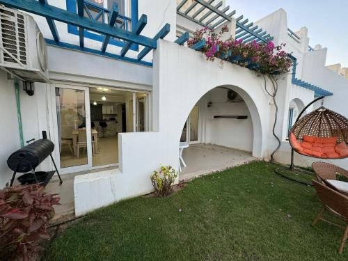 a white house with a balcony with flowers on it at Townhouse in Ras Elhekma