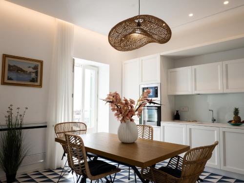 a kitchen with a table with chairs and a vase with flowers at Marina Palace Apartments & Terrace in Lipari