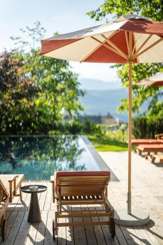 a patio with a table and an umbrella at Castel Sallegg Suites Adults only in Caldaro