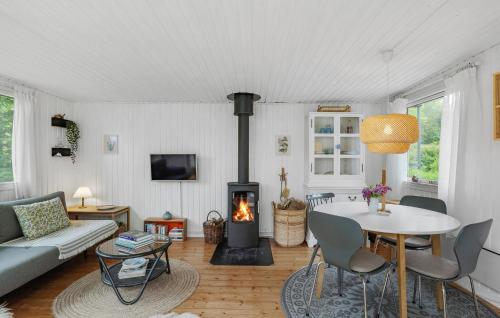 a living room with a table and a fireplace at 2 Bedroom Cozy Home In Hadsund in Hadsund
