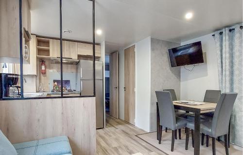 une salle à manger et une cuisine avec une table et des chaises dans l'établissement Mobile Home A-C Proche Plages, à Saint-Julien-en-Born