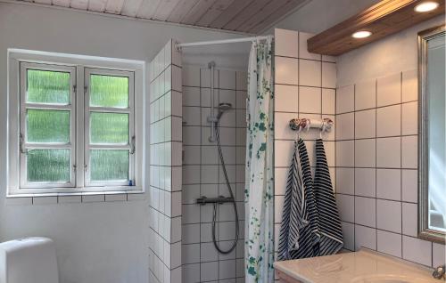 a bathroom with a shower with a black and white shower curtain at 2 Bedroom Beautiful Home In Jægerspris in Jægerspris