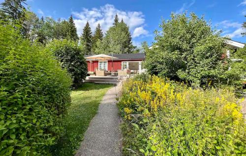 a house in a garden with a path leading to it at Beautiful Home In Gräddö in Gräddö