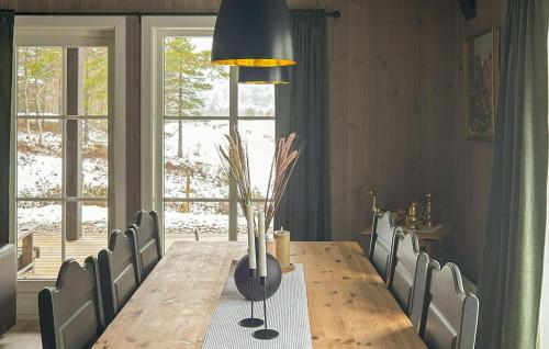 a dining room with a table with chairs and a large window at 4 Bedroom Nice Home In Åmli in Åmli