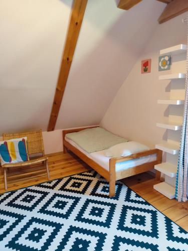 a bedroom with a bed and a staircase and a rug at Fajno Chałupa in Konarzyny