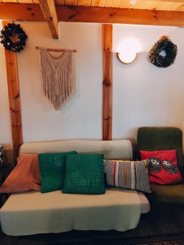 a living room with a couch with pillows on it at Fajno Chałupa in Konarzyny