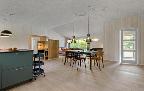 a kitchen and dining room with a table and chairs at 4 Bedroom Gorgeous Home In Oksbøl in Oksbøl