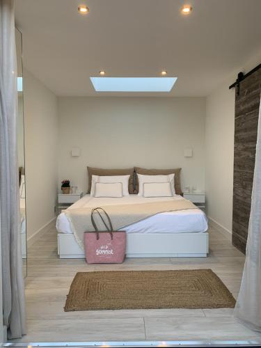a bedroom with a bed with a pink bag on it at Beach House nr 69, dichtbij strand Ouddorp in Ouddorp