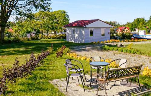 a table and chairs and a bench in a yard at Cozy Home In Sarbinowo in Sarbinowo
