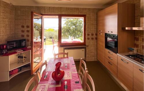 a kitchen with a table with a red vase on it at Villa Larry in San Feliciano