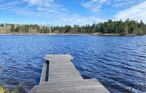 a dock in the middle of a large lake at 1 Bedroom Amazing Home In Mörlunda in Mörlunda