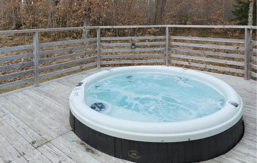 a hot tub on a deck with a fence at Amazing Home In Holmseryd With Wifi in Jälluntofta