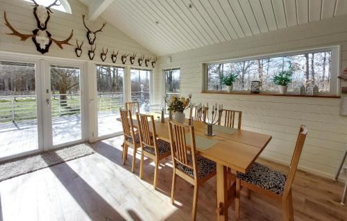 a dining room with a wooden table and chairs at Amazing Home In Holmseryd With Wifi in Jälluntofta