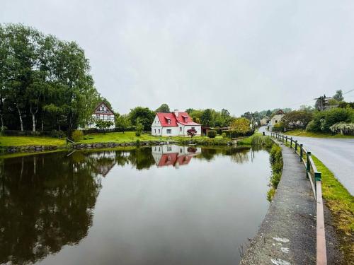 a river with a house on the side of a road at Domeček Drahuška in Janov