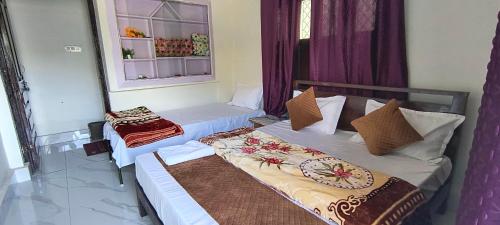 two beds in a room with purple curtains at Hotel Shyalik Palace in Uttarkāshi