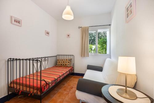 a small bedroom with a bed and a couch at Villa Camaleón in Chiclana de la Frontera