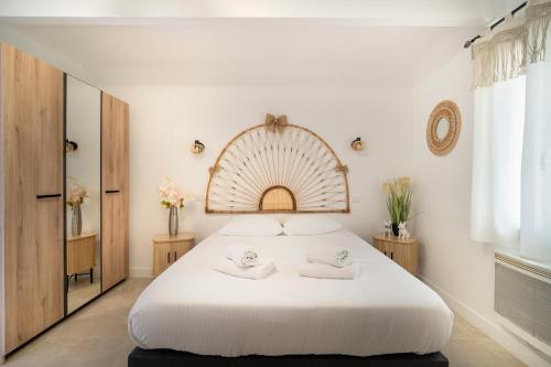 une chambre avec un grand lit blanc avec deux serviettes dans l'établissement Monte Cristo - appt climatisé proche des plages, à Marseille