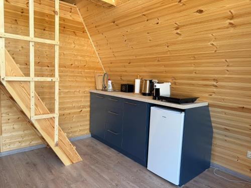 a kitchen in a log cabin with a counter and a ladder at Dino Twins Cottages in Kutaisi