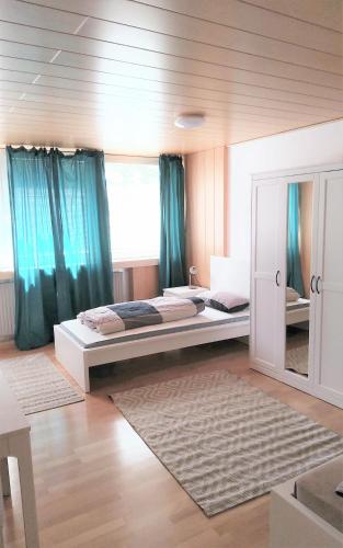 a bedroom with two beds and blue curtains at Monteurwohnung 5 Hoffmann in Heilbronn